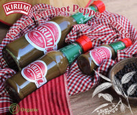 Three bottles of Kirum Kampot pepper sauce on a red checkered cloth with whole peppercorns