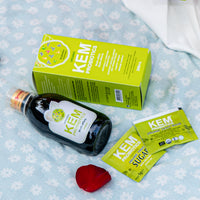 KEM probiotics box, bottle, and sachets displayed on floral fabric