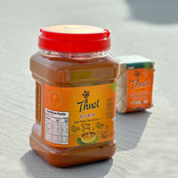 Jar of Thnot palm sugar paste, 1kg, with a woven sugar block in the background